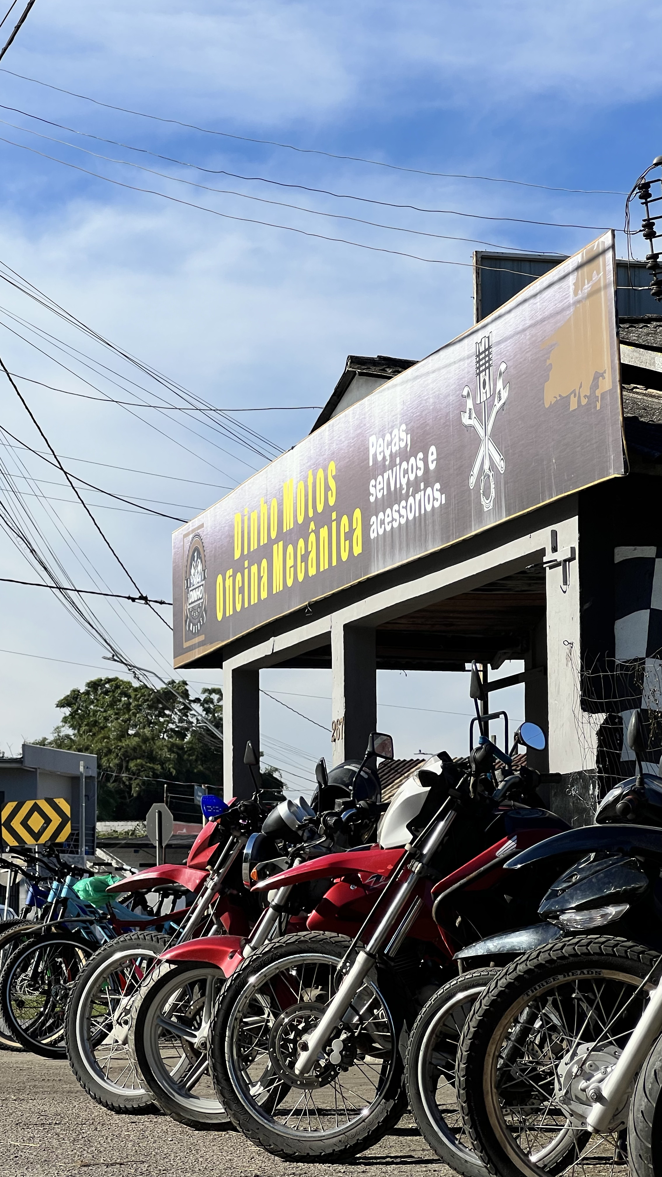 Fachada lateral da Dinho Motos com motos estacionadas em frente
