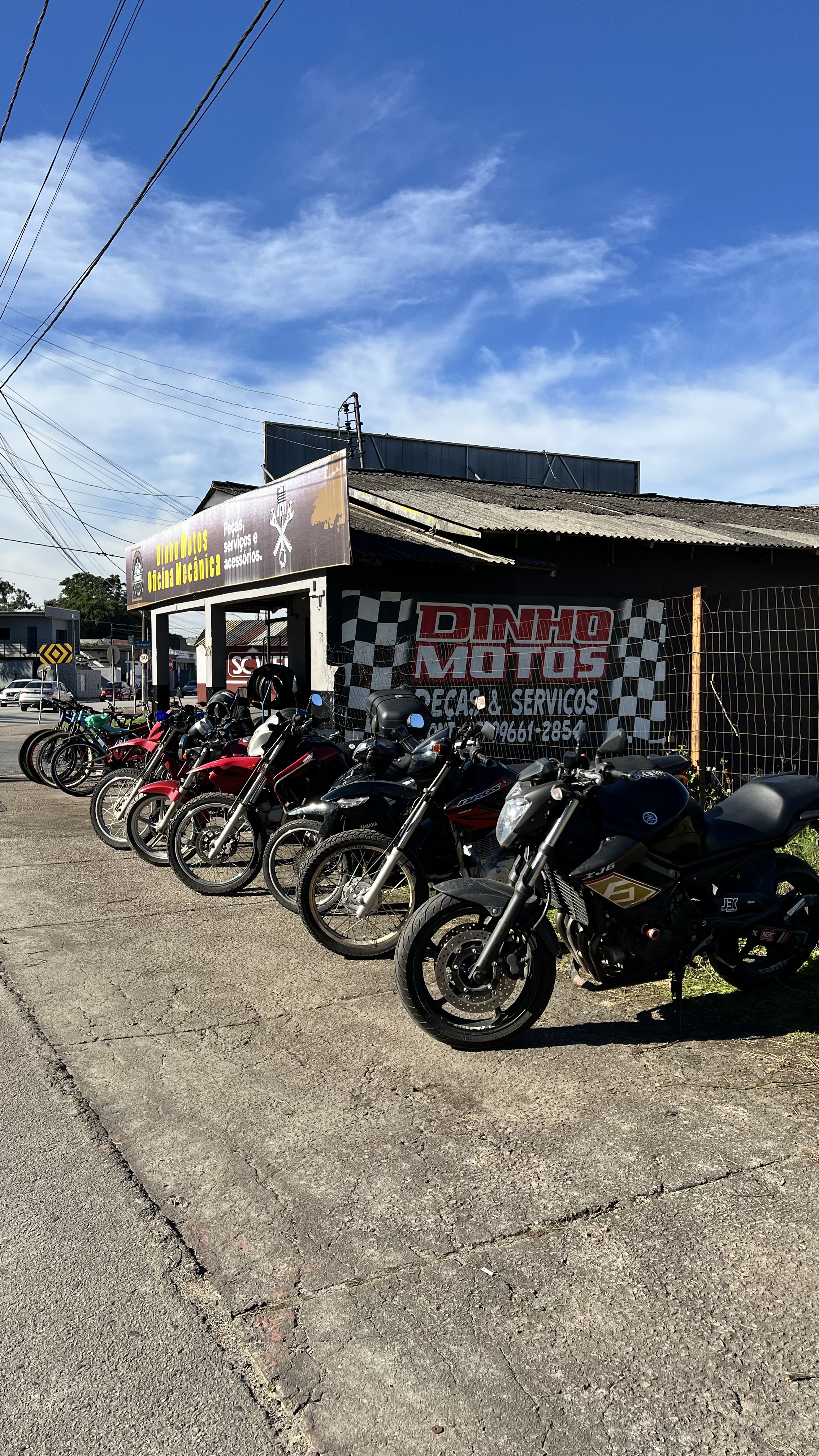 Fila de motos estacionadas em frente à Dinho Motos