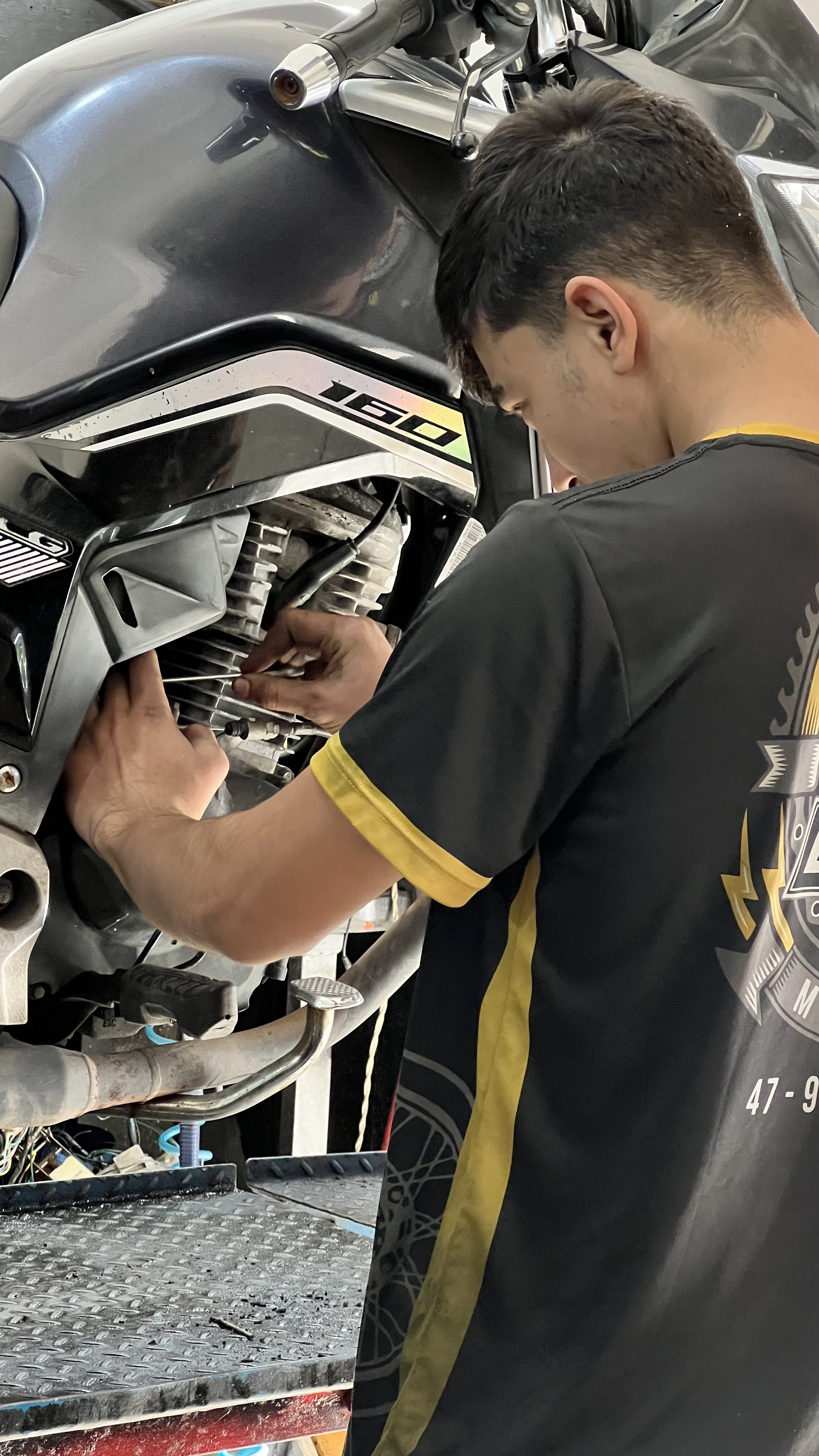 Mecânico da Dinho Motos realizando manutenção em motocicleta